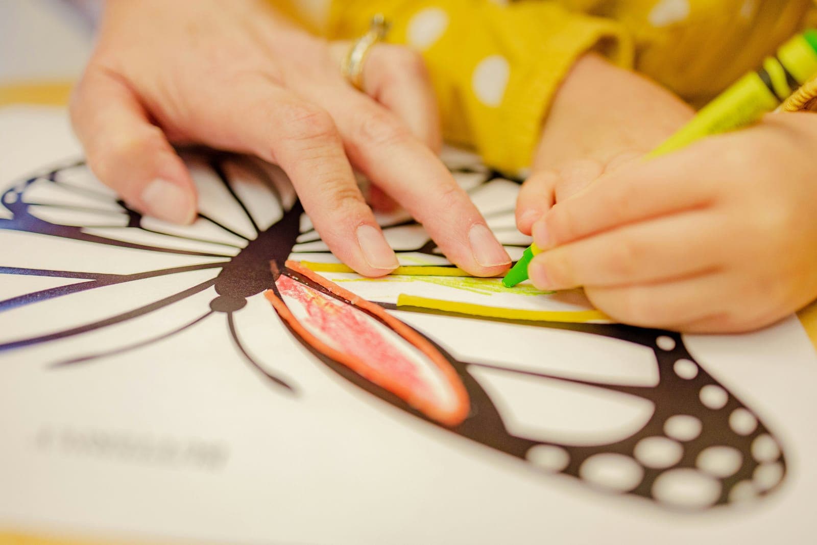 A specialist guiding a child through a coloring activity